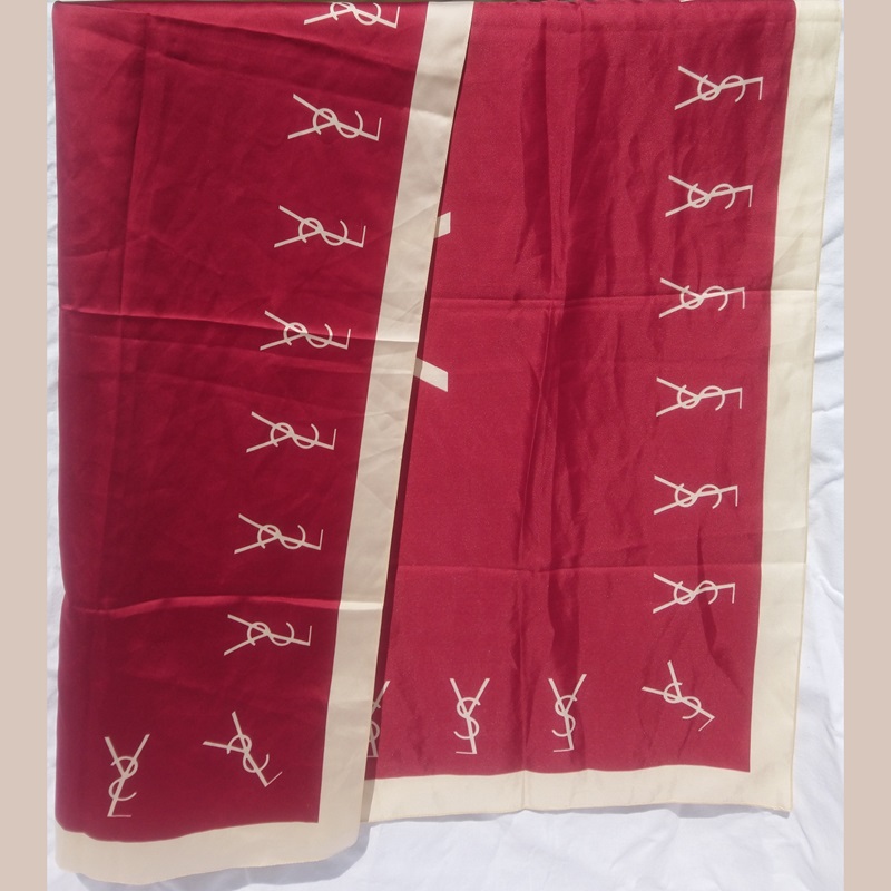 Foulard en soie rouge et beige signé du couturier Français Yves Saint Laurent - Red and beige silk scarf signed by the French designer Yves Saint Laurent. Foulard en soie rouge et beige signé du couturier Français Yves Saint Laurent - Red and beige silk scarf signed by the French designer Yves Saint Laurent.