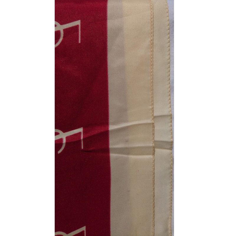 Foulard en soie rouge et beige signé du couturier Français Yves Saint Laurent - Red and beige silk scarf signed by the French designer Yves Saint Laurent. Foulard en soie rouge et beige signé du couturier Français Yves Saint Laurent - Red and beige silk scarf signed by the French designer Yves Saint Laurent.