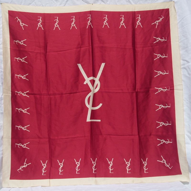 Foulard en soie rouge et beige signé du couturier  Français Yves Saint Laurent - Red and beige silk scarf signed by the French designer Yves Saint Laurent.