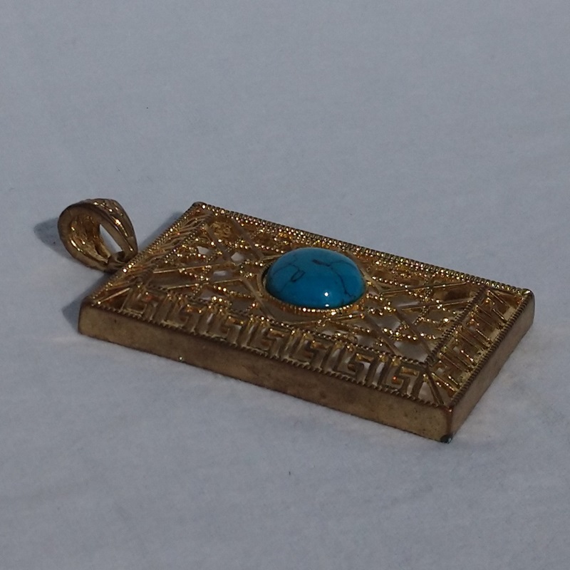 Pendentif vintage en métal doré ciselé et cabochon en pierre turquoise des années 1980 - Vintage gold-plated carved metal pendant with a turquoise stone cabochon from the 1980s Pendentif vintage en métal doré ciselé et cabochon en pierre turquoise des années 1980 - Vintage gold-plated carved metal pendant with a turquoise stone cabochon from the 1980s
